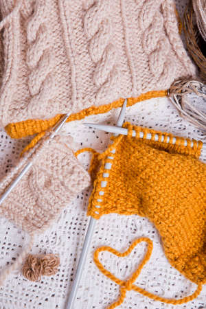 A piece of knitting with ball of yarn and a knitting needles. Knitting project in progress.の写真素材