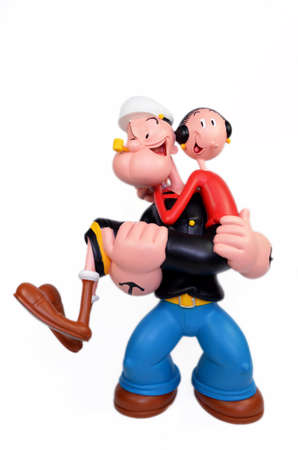 Monchique, Faro - Portugal, June 27, 2013. Studio image of Popeye & Olive Oyl with a white isolated background. Popeye is holding Olive Oyl in his arms while smoking his pipe. Popeye & Olive Oyl is a fictional character created by Elzie Crislerのeditorial素材