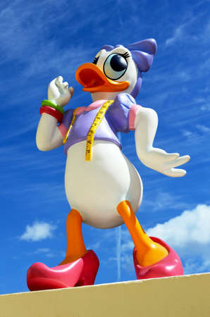 Monchique, Faro - Portugal, 30th, March 2013. Studio image of Daisy Duck figure Standing on a wall with a blue sky background.  Daisy Duck was produced by Walt Disney.のeditorial素材