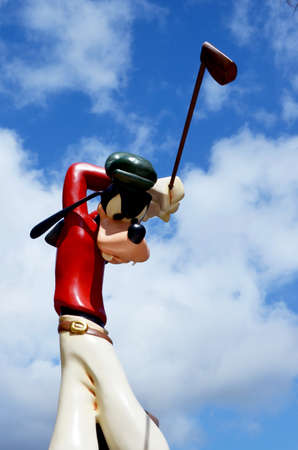 Monchique, Faro - Portugal, Circa, March 2013. Studio image of Goofy figure swinging a golf club with a blue sky background.  Goofy was produced by Walt Disney.のeditorial素材