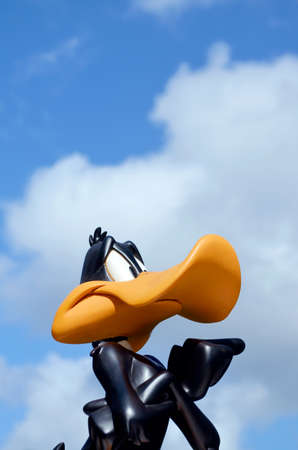 Monchique, Faro - Portugal, 01 April, 2013. Studio image of Daffy Duck figure with a blue sky background with light cloud cover. Daffy Duck was created by Warner Bros.のeditorial素材