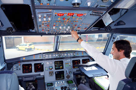 Portugal, Algarve, Faro. Circa 10th July 2013. Picture of a tap airline commercial airplane cockpit with Pilot reaching out for controls. Picture taken taken when plane landed at destination at Faro.のeditorial素材