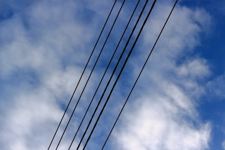 Electric power line against a background of a cloudy blue skyの写真素材