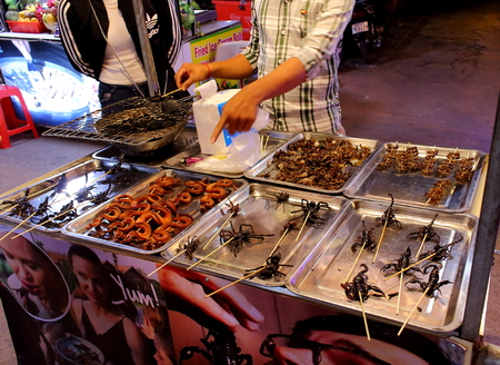 SIEM REAP, CAMBODIA - Mart 22, 2018: Tarantula, scorpion and snake kebab for sale on the counter of a street food vendor in Cambodia. Exotic food for tourists and travelersのeditorial素材