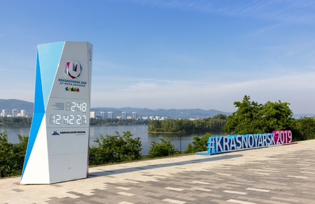 KRASNOYARSK, RUSSIA - June 27, 2018: Cityscape of the embankment of the of the Yenisei river with hashtag and countdown to the start of XXIX Winter Universiade in summer dayのeditorial素材