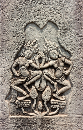 Dancing Apsaras of detail religious stone carving decorating on ancient wall Angkor Wat Temple at...