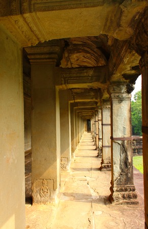 An open stone gallery illuminated by the sun in the ancient Angkor Wat temple in Siem Reap, Cambodia.の写真素材