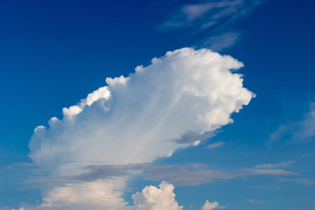 Amazing white cloud like a dirigible on a background of saturated blue skyの写真素材