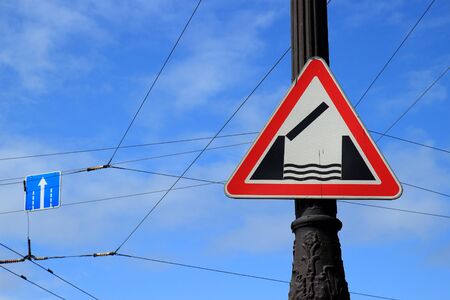 Warning road sign 'Drawbridge' on pillar against the background of the blue sky. Installed in front of a swing bridge or ferry Warning road sign 'Drawbridge' on pillar against the background of the blue sky. Installed in front of a swing bridge or ferry