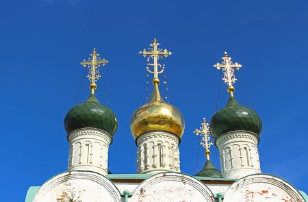 Gold domes Orthodox church brilliant in the sun. Crosses of the white Orthodox church on the background of bright blue sky in summer day, Zaraysk, Russiaの写真素材