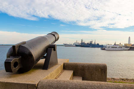 Kronstadt, St. Petersburg, Russia - August 15, 2020: Noonday Gun Memorial overlooking the ships of the Navy in the Middle harbor on the shore of the Gulf of Finland. Russian memorial fort cannon.のeditorial素材