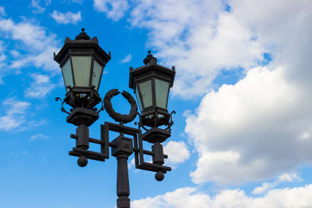 City decorative street lantern on cloudy sky background. Urban metal lamppost in retro styleの写真素材