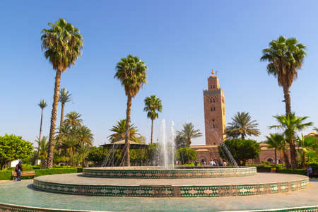Marrakesh, Morocco - 12 October, 2019: Sunny view of Koutoubia Mosque from the city park Lalla Hasna with fountains and palm treesのeditorial素材