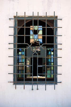 Window on a white plastered wall is decorated with a decorative lattice with an octagram. Moroccan authentic exterior traditional for medina quarter at Tangierの写真素材