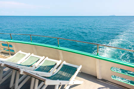 Empty deck chairs on the upper deck of a cruise ship. Sun loungers on the sea yacht for relaxing