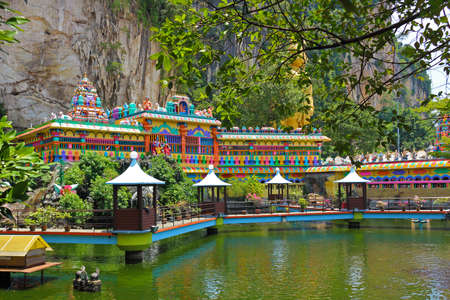 Kuala Lumpur, Malaysia - March 15, 2019: landscaped area with colorful Hindu temple on water near...