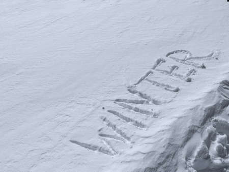 Inscription Winter written on pure white snow. Winter holiday concept. Top view, copy spaceの写真素材