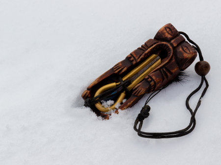 Ethnic musical instrument of jew's harp in a wooden case on white snowの写真素材