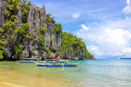 Puerto Princesa, Palawan, Philippines - September 26, 2018: Filipino boats in azure lagoon against rocks. Coast near Puerto Princesa Subterranean River National Park.のeditorial素材