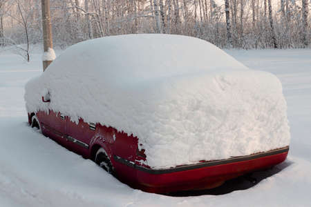 Red car buried with deep snow on parkingの写真素材