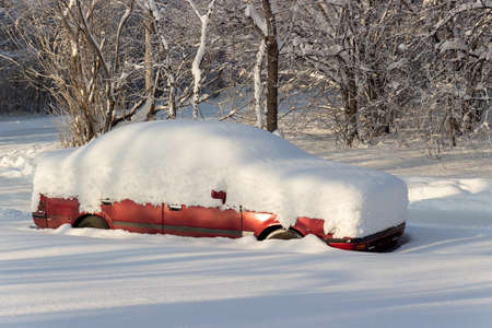 Car under deep snow. Blizzard in the city. Transport buried on parkingの写真素材