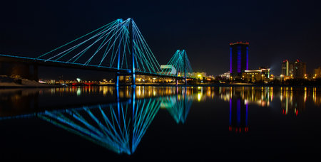 Night landscape with a bridge over the Yenisei River in Krasnoyarsk, Russia. Blurred reflection...