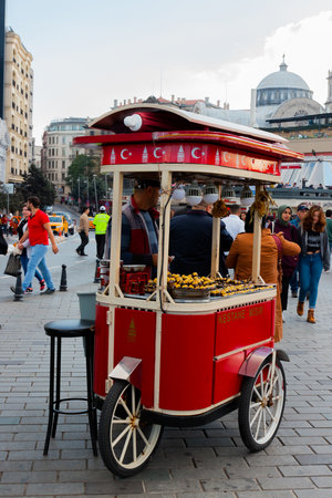 Istanbul, Turkey - October 6, 2019: a street vendor of roasted chestnuts in Istanbul. Traditional Turkish cart on Taksim square.のeditorial素材