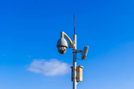 Outdoor Wireless Controlled Security Surveillance Camera on pole against blue sky backgroundの写真素材
