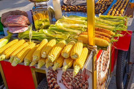 Istanbul, Turkey - October 6, 2019: roasted chestnuts and golden corn on the cart of a street vendor...