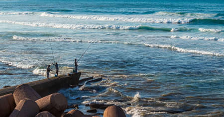 Casablanca, Morocco - 21 October, 2019: three fishermen catch fish on the shores of the Atlantic Ocean in Casablanca, Morocco.のeditorial素材