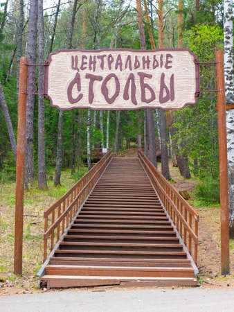 Krasnoyarsk, Russia - May 21, 2021: Welcome sign of 'Central Pillars' and wooden stairway at the...