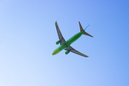 Krasnoyarsk, Russia - 16 August, 2021: Green passenger airplane of S7 airlines flying in blue sky. Commercial airliner in flightのeditorial素材
