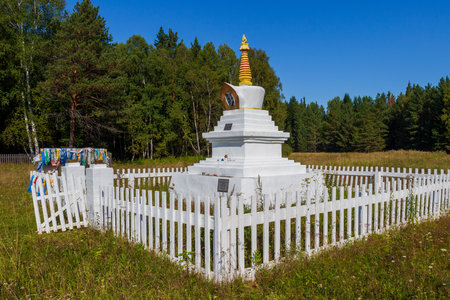 Ritual Buddhist stupa of a Enlightenment behind a white wooden fence on green meadow against forest near Krasnoyarsk, Russia. Translation: Buddhist Bodhi Stupaの写真素材
