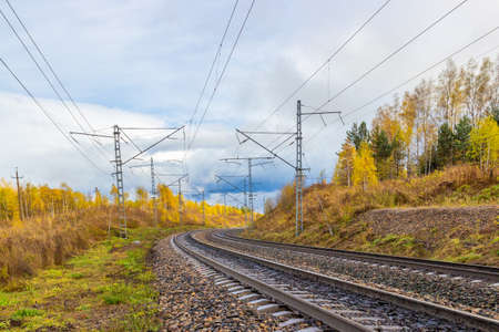 Golden autumn landscape on empty curved railroad in Siberia. Industrial landscape. Railroad tracks...