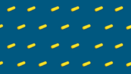 Repeating of yellow pills on blue background. Capsule pharmacy drugs. Medical seamless patternの写真素材