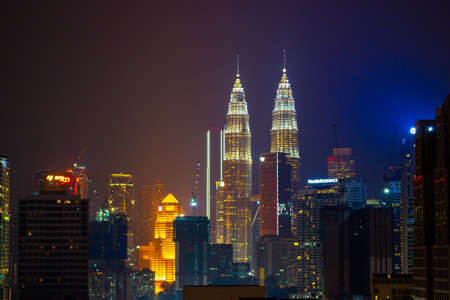 Kuala Lumpur, Malaysia - March 15, 2019: night aerial view on the Kuala Lumpur city from the viewpoint on the Menara TV Tower. Glowing Petronas Twin Towers and the Kuala Lumpur skyscrapersのeditorial素材