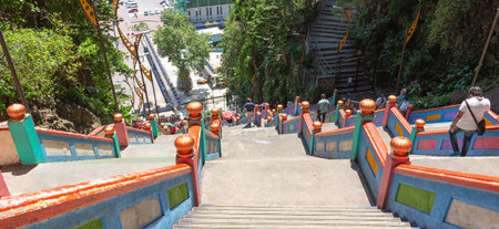 Kuala Lumpur, Malaysia - March 15, 2019: people go down and up the long stairs in Batu caves in...