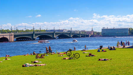 St. Petersburg, Russia - 16 August, 2020: people sunbathe and resting on the grass near Peter and...