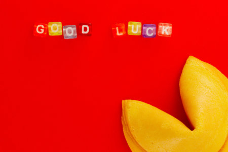 Inscription Good Luck from colorful plastic cubes with chinese fortune cookie on red background with copy space. Ideas concept -You will definitely get lucky.の写真素材