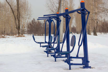 Street fitness workout in winter. Gym in the open air in winter. Free outdoor gym with exercise...
