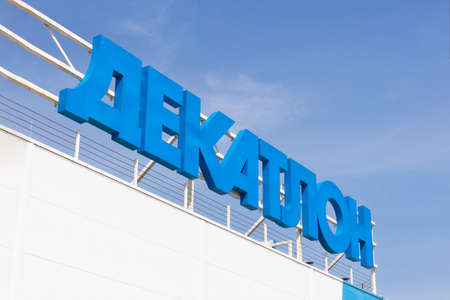 Krasnoyarsk, Russia - May 19, 2022: Close-up of Decathlon brand logo against blue sky. Decathlon SA is a French sporting goods retailer. Decathlon stores closed in Russia due to world sanctionsのeditorial素材