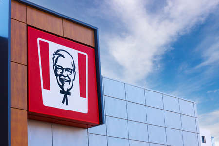 Krasnoyarsk, Russia - May 19, 2022: KFC restaurant logo on glass facade building. Portrait of Colonel Sanders - the symbol of the KFC. KFC is a fast food restaurant chain specializes in fried chickenのeditorial素材