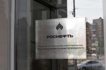 Krasnoyarsk, Russia - May 29, 2022: Plate with Rosneft name on glass door. Entrance to office of PJSC Rosneft Oil Company - Krasnoyarsknefteproduktのeditorial素材