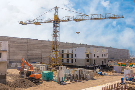 Construction site with a construction crane building a high-rise residential building from modern...