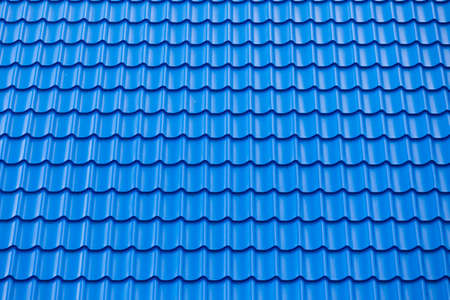 Architectural textured background of blue roof metal tile. Roof of a house with modern metal roof...