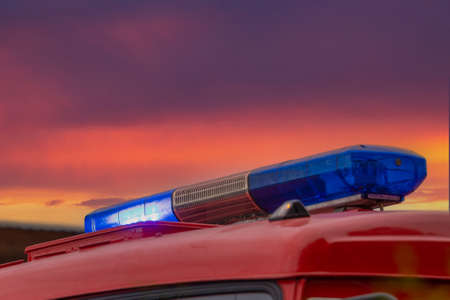 Blue emergency lights off on red fire truck against a purple-red stormy sky. Light of fire engines. emergency vehicle lightingの写真素材