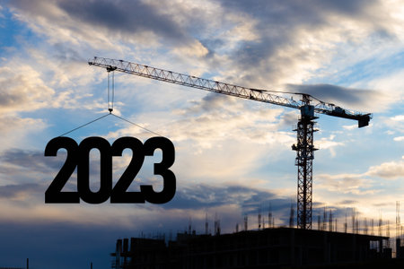 Concept for New Year 2023 for marking and construction plans. Future planning and goals. Silhouette of a construction crane at a construction site raising the number 2023 year.の写真素材