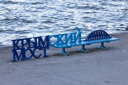 Moscow, Russia - 14 November, 2022: Krymsky bridge blue bench on the Moscow river embankment. Model and inscription Crimean bridge on the benchのeditorial素材
