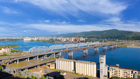 Summer cityscape with road and railway bridges across the Yenisey river in Krasnoyarsk, Russia. panoramic view.の写真素材
