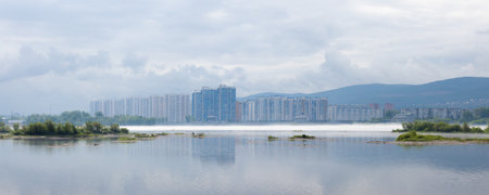 Morning fog over the Yenisey river hides the city. Cityscape of the city of Krasnoyarsk, Russia.の写真素材